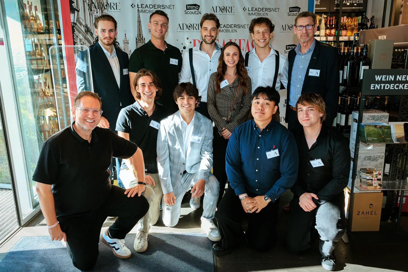 Gruppenfoto des Teams vor der Breakfast-for-Immos-Fotowand